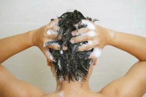 een Mens is het wassen zijn haar- met shampoo foto