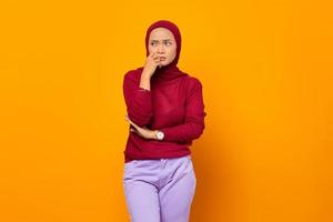 mooie Aziatische moslimvrouw die aan iets denkt foto
