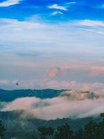 de verbijsterend visie van een toeristen standpunt net zo ze Gaan naar beneden een heuvel Aan een mistig spoor met een heuvel en een achtergrond van een gouden lucht in Woud park, Thailand. vogel oog visie. antenne visie. foto