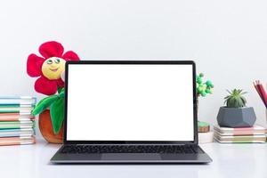open laptop mock-up op kinderwerkplek met boek en speelgoed foto