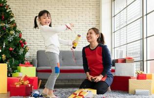Aziatische moeder en dochter vieren thuis kerstmis met confetti foto