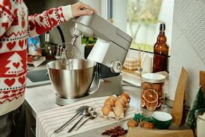 vrouw Koken Bij huis keuken, gebruik elektrisch menger naar voorbereidingen treffen deeg foto