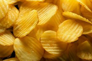 gouden aardappel chips structuur creëert een verleidelijk en knapperig backdrop ai gegenereerd foto