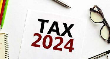 belasting 2024 Aan papier met bril, pen en potloden foto
