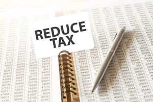 tekst verminderen belasting Aan papier kaart, pen, financieel documentatie Aan tafel foto