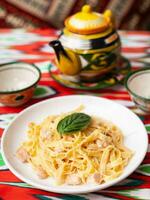 romig pasta met kip, basilicum en paddestoelen, volgens naar de Italiaans recept. oosten- stijl foto