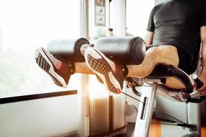 close-up van man tillen gewicht door benen om uit te rekken op fitness gym