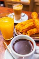 typisch Spaans churros geserveerd met kop van heet chocola in sevilla, Spanje foto