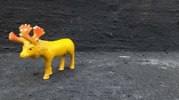 close-up van een gele herten dierlijke speelgoedpresentatie op grijze achtergrond foto