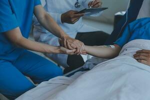 Dames Aziatisch artsen houden de geduldig hand- en aanmoedigen en voorzien medisch advies terwijl controle de geduldig Gezondheid in bed. concept van zorg en medeleven, prenataal zorg, bedreigd abortus foto