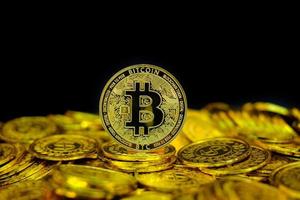 gouden bitcoin cryptocurrency op stapel gouden munt op zwarte achtergrond