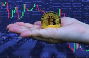 vrouw hand met gouden bitcoin cryptocurrency foto