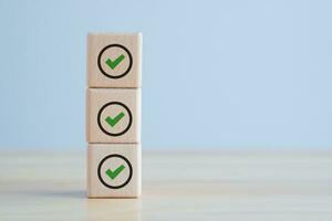 checklist enquête en beoordeling. kwaliteit controle. doelen prestatie en bedrijf succes. houten stack met groen controleren markering. foto