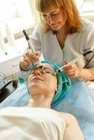 schoonheidsspecialist maakt de procedure microstroom behandeling in een schoonheid salon foto
