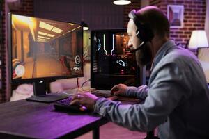 gamer gebruik makend van deskundige rang niveau gaming computer naar vermijden storend vertraging terwijl spelen esports wedstrijden. Mens ontspannende Bij huis spelen actie schutter videogame laat Bij nacht foto