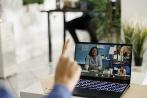 bedrijf partners bespreken project strategie in video-oproep Aan laptop scherm. uitvoerend managers coworking van een afstand in video conferentie Aan portable computer met werknemer in coworking ruimte foto