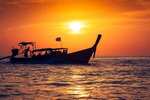 visvangst boot met zonsondergang in phi phi eilanden, Thailand foto