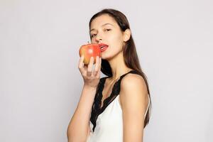 gezond aan het eten. vrouw bijten rood appel met perfect tanden foto