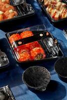 reeks van sushi broodjes Ingepakt in Gesloten plastic containers voor levering naar cliënt foto