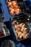 sushi broodjes met Zalm en paling Ingepakt in plastic meenemen containers met soja saus foto