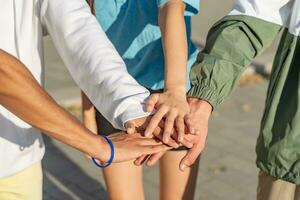 leerling samenspel stapelen verschillend handen samen. multicultureel groep. foto