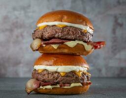 twee cheeseburgers met spek, ui en mayonaise foto