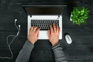 direct bovenstaand visie van menselijk handen typen Aan laptop. foto