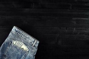 zak- geld. dollar in heup zak- van versleten blauw jeans. detailopname. foto