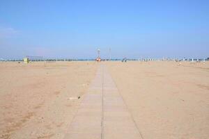 een lang loopbrug Aan de strand foto