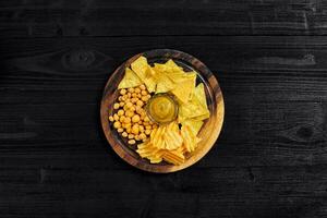 overhead visie van snacks met saus Aan zwart houten tafel. foto