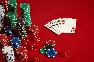 casino het gokken poker uitrusting en vermaak concept - dichtbij omhoog van spelen kaarten en chips Bij rood achtergrond. vol huis foto