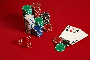 casino het gokken poker uitrusting en vermaak concept - dichtbij omhoog van spelen kaarten en chips Bij rood achtergrond. drie van een soort foto