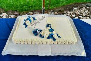 een wit taart met blauw decoraties Aan top foto