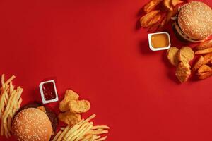 twee hamburgers en Frans Patat, sauzen Aan rood achtergrond. snel voedsel. top visie. foto