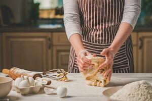 vrouw handen kneden deeg Aan keuken tafel foto