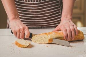 vrouw snijdend brood Aan houten bord. bakkerij. brood productie. foto