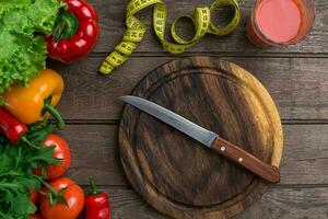 sport en eetpatroon. groenten, een glas van tomaat sap en centimeter. pepers, tomaten, salade Aan rustiek achtergrond foto