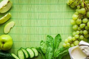 ingrediënten voor groen ontgiften smoothie. spinazie, druif, yoghurt, komkommer en appels Aan groen achtergrond foto