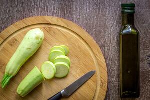 een gesneden courgette Aan een houten bord. houten achtergrond foto