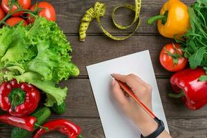 sport en eetpatroon. groenten en centimeter. pepers, tomaten, salade Aan rustiek achtergrond foto