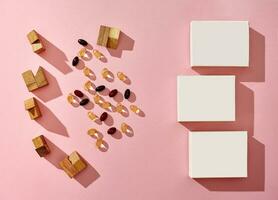 drie klein karton dozen met Nee logo, verspreide kleurrijk capsules en houten blokken van verschillend vormen Aan roze achtergrond. dichtbij omhoog, kopiëren ruimte foto