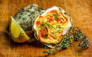 gebakken oester schelp met kaas, geserveerd peterselie en citroen foto