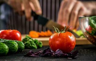 mannetje handen snijdend groenten voor salade foto