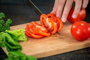 mannetje handen snijdend groenten voor salade foto