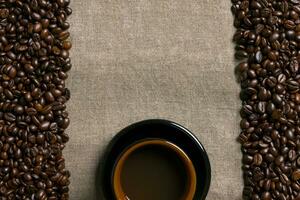 koffie bonen en koffie kop Aan een jute achtergrond foto
