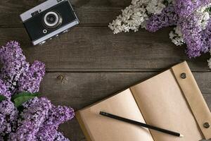 lila bloesem Aan rustiek houten achtergrond met notitieboekje voor groet bericht. top visie foto