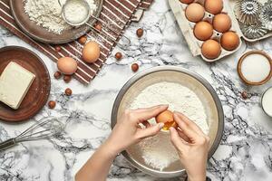 detailopname schot. top visie van een bakker koken plaats, handen zijn werken met een rauw deeg Aan de marmeren tafel achtergrond. foto