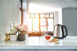 ontbijt tafereel Bij zonnig ochtend. transparant zwart thee mok met biscuit Aan keuken tafel foto