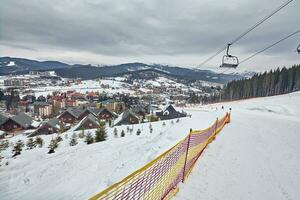 panorama van ski toevlucht, helling, mensen Aan de ski tillen, skiërs Aan de piste tussen groen pijnboom bomen en sneeuw lansen. foto