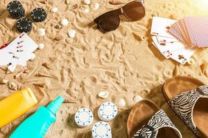 strandpoker. chips en kaarten Aan de zand. in de omgeving van de schelpen, zonnebril en omdraaien flopt. top visie foto